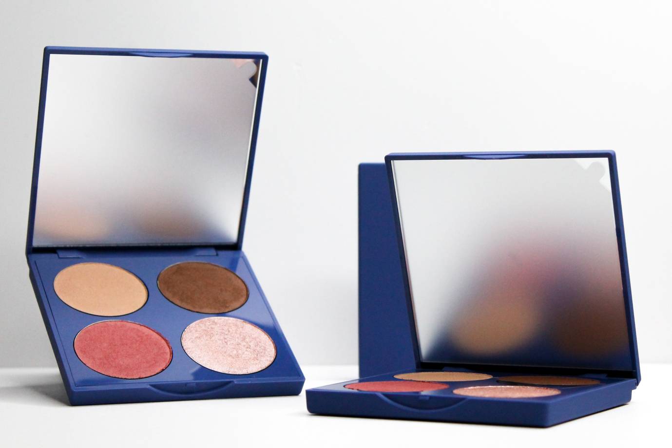 Open makeup palettes with four shades and mirrors.