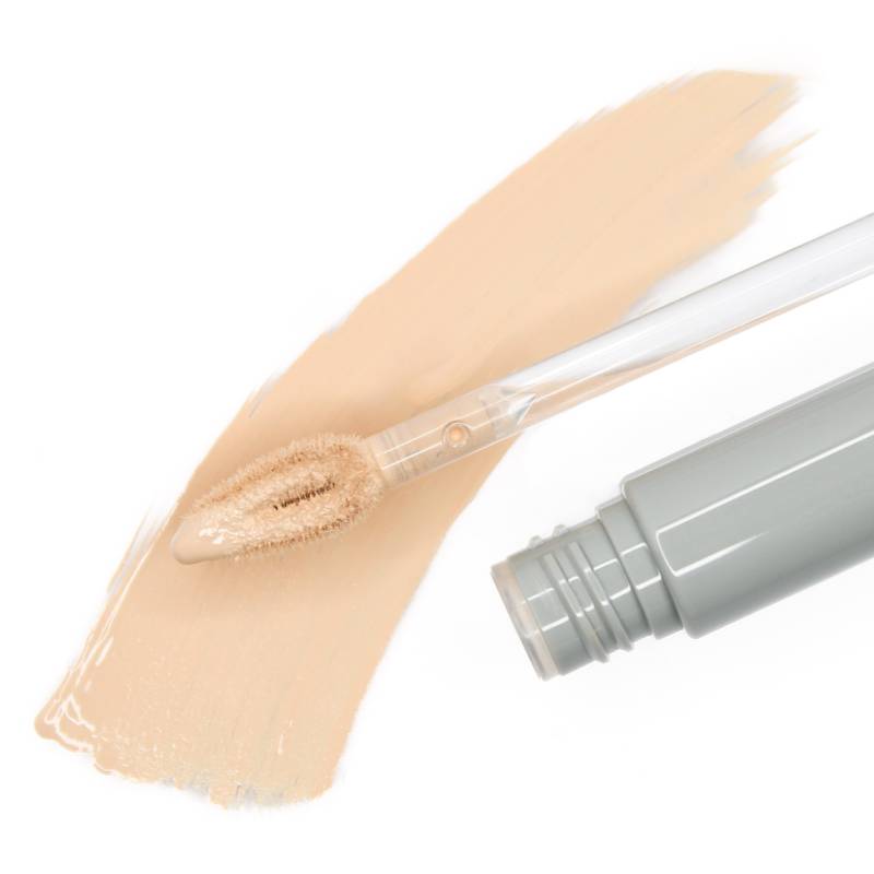 Beige liquid concealer with smooth texture and applicator on white background