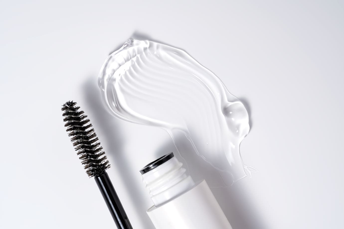 Clear eyebrow gel with fiber brush, open tube, and product swatch
