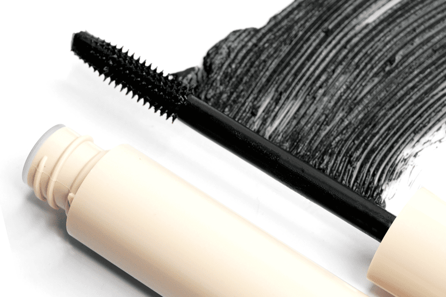 Mascara brush displayed over a black tubing mascara formula swatch
