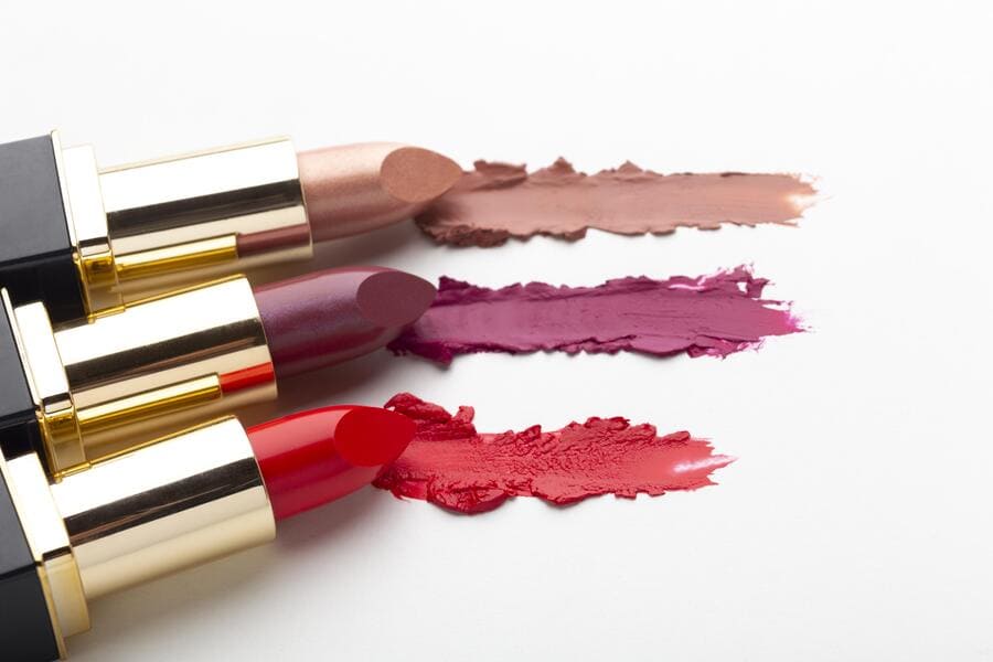 Three lipsticks in nude, berry, and red with matching color swatches