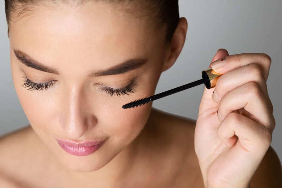 Woman applying an eyelash treatment to enhance her lashes