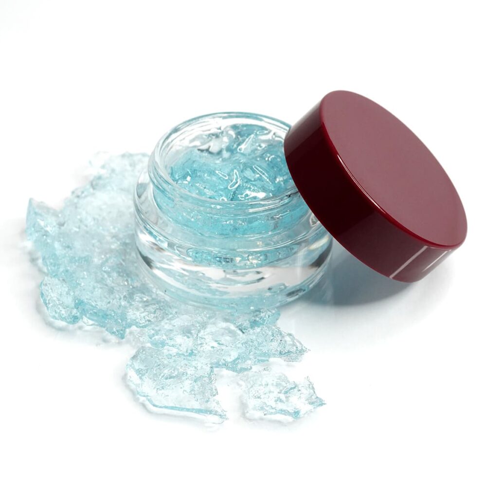 Open jar with blue gel texture and burgundy lid on white background